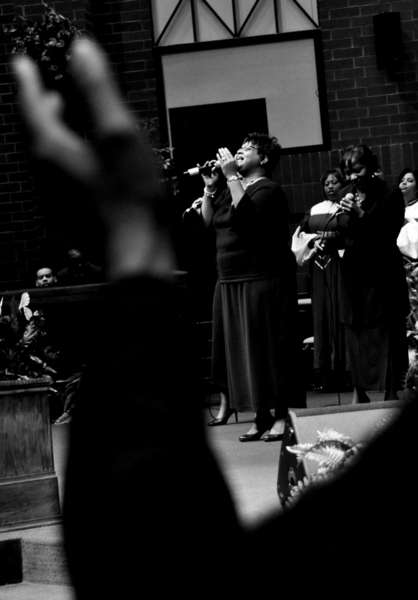 The "Heavenly Women" ensemble, lead Zola Johnson, sings at the alter during a service. 