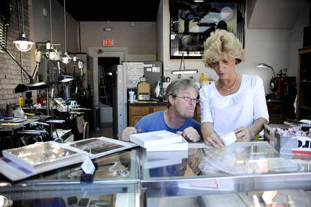Tim and Angela check their inventory before they place the jewelry in front of the glass counter at Stoll's Custom Jewelers. Stoll's usually displays retail-made rings alongside Tims original designs.