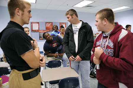 Mitchell Henry, center right, discusses football with his classmates during a break from their business class. Mitchell usually finds himself in the spotlight, even when he does not look for it.