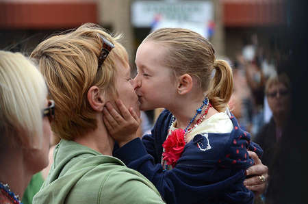 As Jessica Newman, 5, waited for her father to come down from the USS Vinson carrier, she kissed her mother out of excitement.