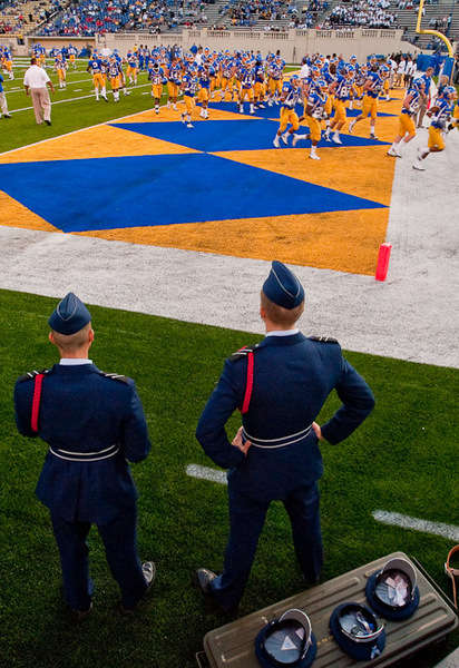 Military service men watching the football game on Spartan field.