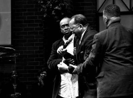 Bishop George W. Brooks is held down by two members of his congregation, during a passionate preach during a  service.