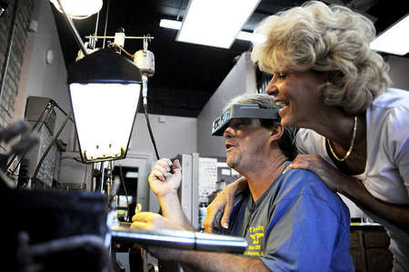 Angela leans on Tim after he finishes a yellow gold ring that he made in just 24 hours. Work orders usually take weeks to be completed.