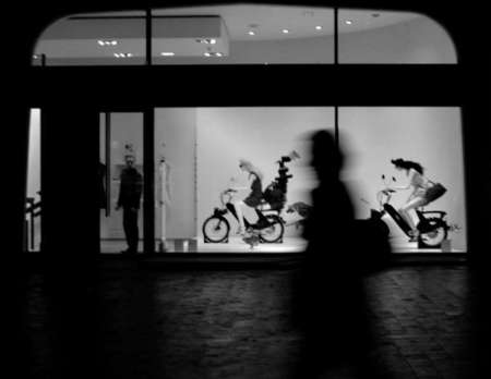 A pedestrian passes through a Parisian boutique. 