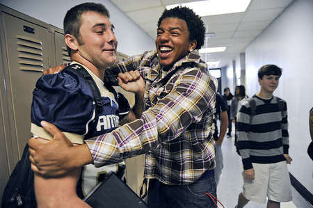 Titus Sublet, 19, embraces Mitchell Henry, left, to wish him luck before the big homecoming game. Titus is a recent graduate of Elizabethtown High School and now attends Elizabethtown Community & Technical College. He used to be a part of the EHS football team and is still good friends with Mitchell.